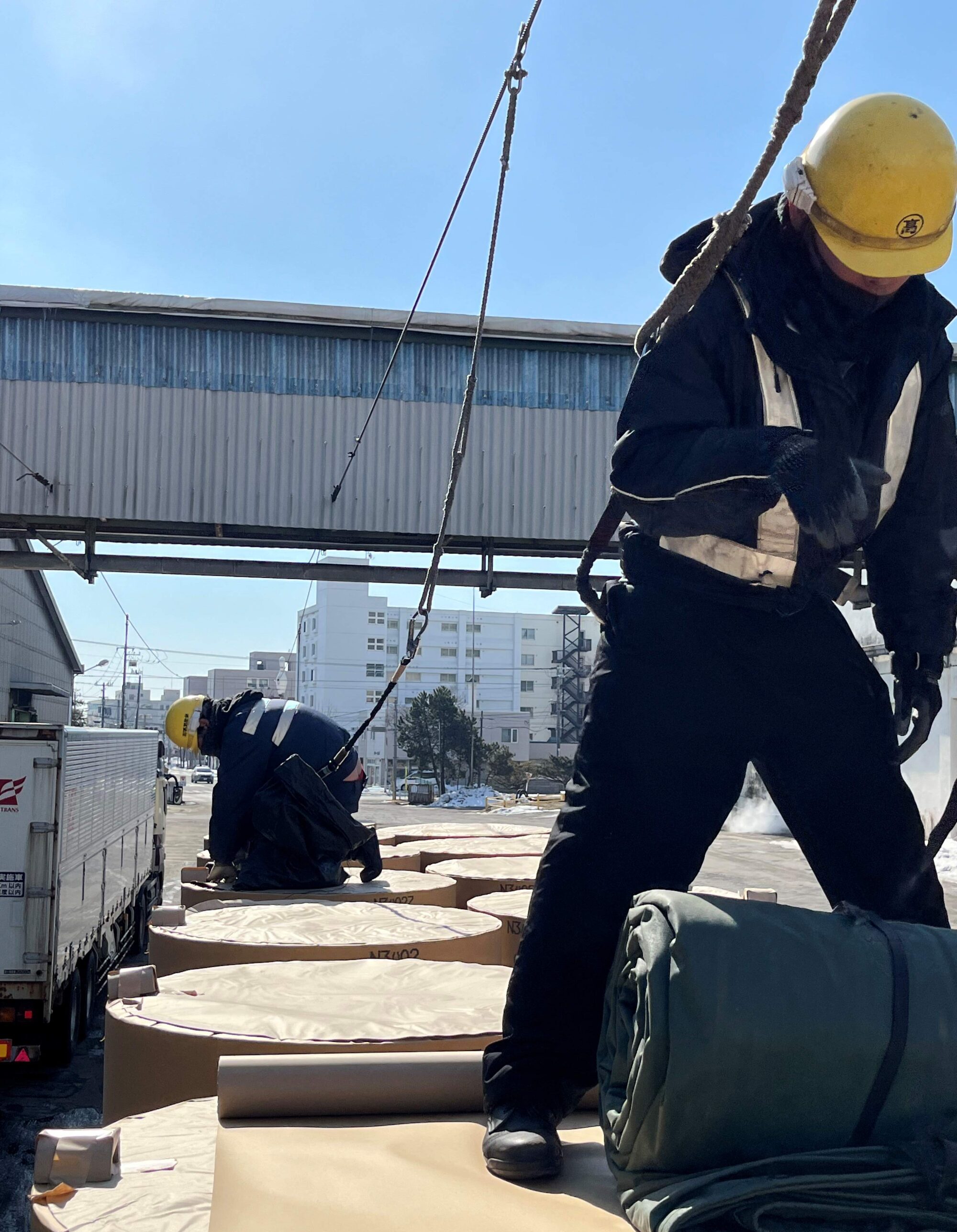 トラックの荷台シート掛け補助作業員 